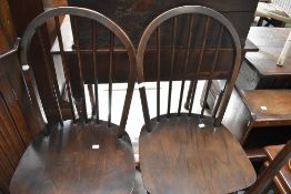 A set of four dark stained Ercol kitchen chairs, hoop and stick back