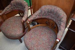 A pair of late Victorian low back arm chairs having inlayed mahogany frames on turned legs