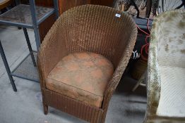 A vintage Lloyd Loom tub chair with upholstered seat