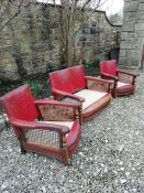 An early Ercol Arts and Crafts three piece suite having embossed leather back, bergere cane sides,