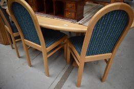 A modern Ash oval dining table and 6 chairs having upholstered seats and backs