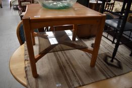 A modern Ercol square coffee table having glass undershelf