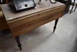 A Victorian part stripped drop leaf kitchen table having frieze drawer, on turned legs and later