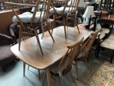 A light Ercol extending dining table having double centre leaf (Grand Windsor) and a set of six (