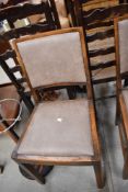 A set of four early 20th Century oak dining chairs having late upholstered seats (with fire labels)