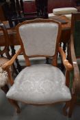 A reproduction French style stained frame and upholstered armchair