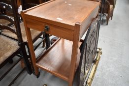 A teak tea trolley having integral drawer