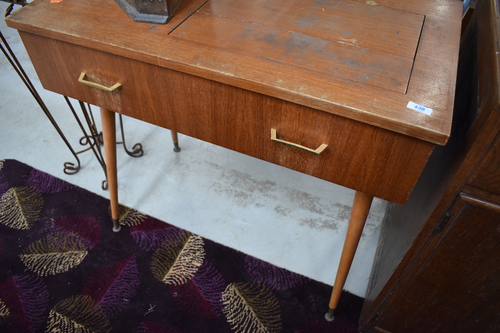 A vintage teak side table, previously housing a sewing machine, on dansette style legs