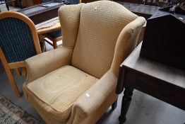 A reproduction wing back armchair
