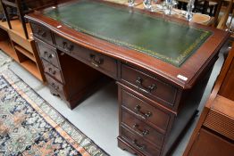 A modern reproduction low knee hole desk having green leather top and drawer sets