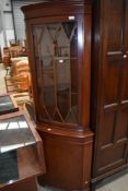 A reproduction mahogany corner display cabinet with lower cabinet section