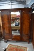 An early 20th Century flame mahogany mirror door triple wardrobe