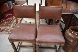 A pair of mid 20th Century stained frame dining chairs having rexine studded seats and backs