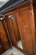 A Victorian mahogany mirror door triple wardrobe/linen press having fitted section