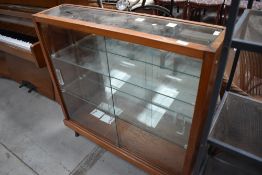 A vintage pitch pine display case with mirror back