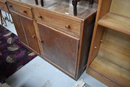 A late Edwardian oak utility or kitchen cupboard dresser base