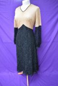 A 1930s black and taupe lace dress having silk lining and belted waist.