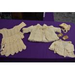 A collection of baby and childrens clothing including fur coat and bonnets, mostly around 1920s.