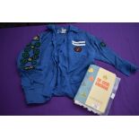 A 1960s girl guides blouse with badges and a copy of the guide book.