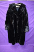 A striking vintage black fur coat having wide sleeve openings with turn up and shawl collar,serviced