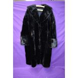 A striking vintage black fur coat having wide sleeve openings with turn up and shawl collar,serviced