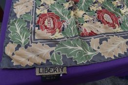 A Liberty of London silk scarf having floral pattern in red and green on grey ground.