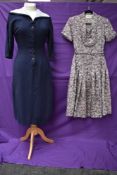 A vintage 1950s St Michaels tea dress with floral pattern and belt and similar navy blue dress