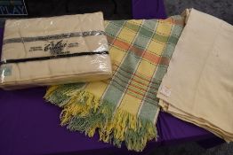 Three vintage wool blankets including one in original packaging and green and yellow checked