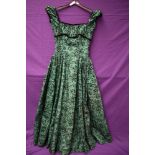 A green Rosecroft model 1950s gown having flocked floral detailing,velvet trim to under bust, sleeve