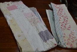 A large vintage quilt using a variety of cotton sections in various colours and patterns, some