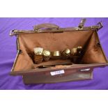 A vintage brown leather clasp top overnight/vanity bag having a set of ladies accessories to