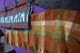 Two vintage rugs,one with pattern to green ground and the other checked in autumnal tones.