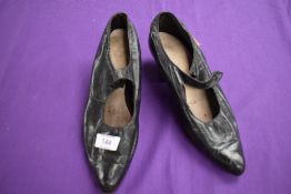 A pair of antique black leather shoes.