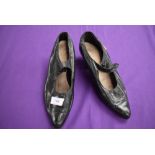 A pair of antique black leather shoes.