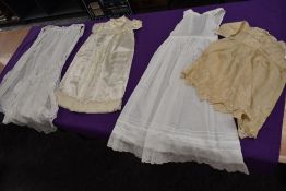 A collection of baby clothing including gowns and apron, all around 1920s.