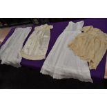 A collection of baby clothing including gowns and apron, all around 1920s.