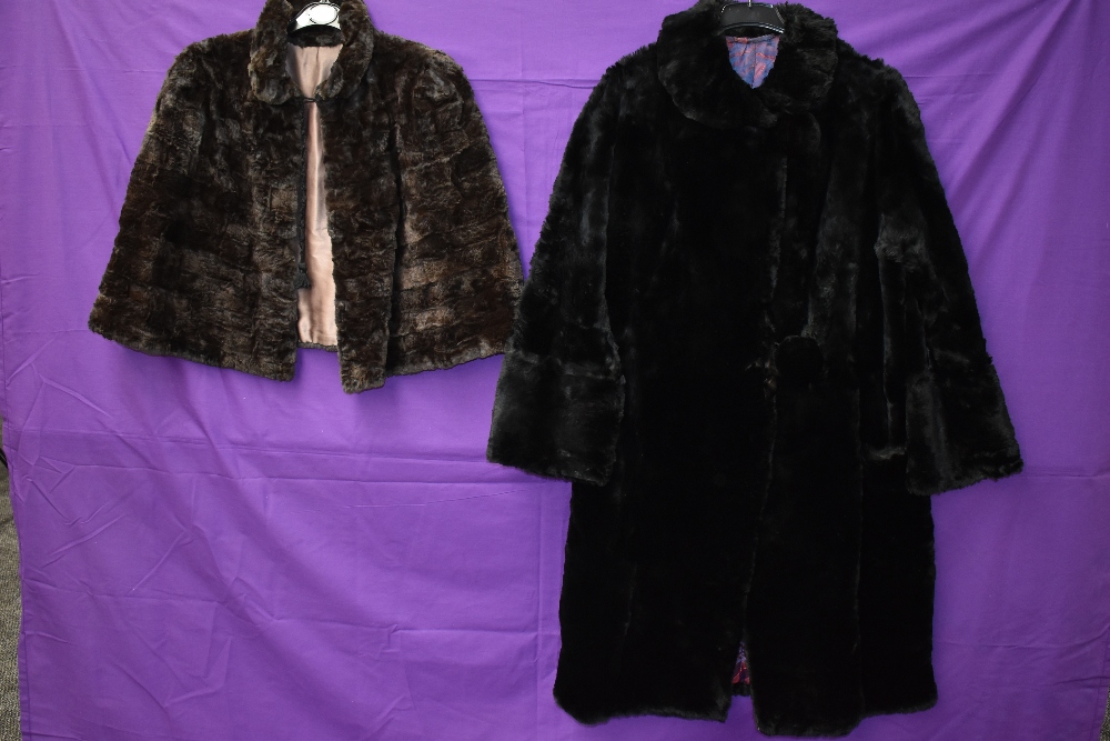 A black 1940s fur coat having pom pom fastenings and a 1940s brown mole skin cape.