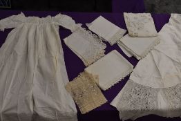 A selection of bed and table linen, cut work, tulle sections and a childs antique gown,included