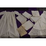 A selection of bed and table linen, cut work, tulle sections and a childs antique gown,included