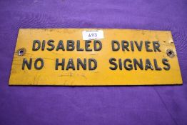 A vintage 'Disabled driver, no hand signals' plate