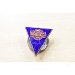 An AEC lapel badge.