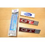 Four vintage motor car engine badges, a Ford Cortina, two GT and a Ford