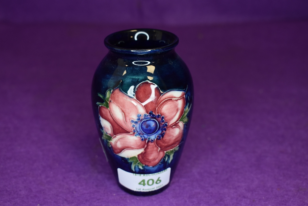 A small size Moorcroft vase having deep blue ground with Anemone design 10cm tall