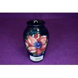 A small size Moorcroft vase having deep blue ground with Anemone design 10cm tall