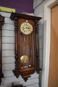 A British enamelled faced wall clock having weighted pendulum in mahogany case