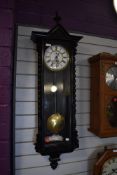 An enamel faced wall clock having single weight pendulum