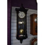 An enamel faced wall clock having single weight pendulum