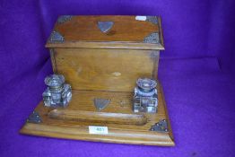 A golden oak Edwardian writers compendium or desk tidy having double ink well