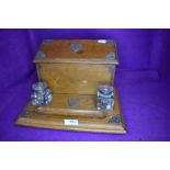 A golden oak Edwardian writers compendium or desk tidy having double ink well