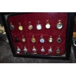 A glazed display case containing eighteen pocket watches or time pieces